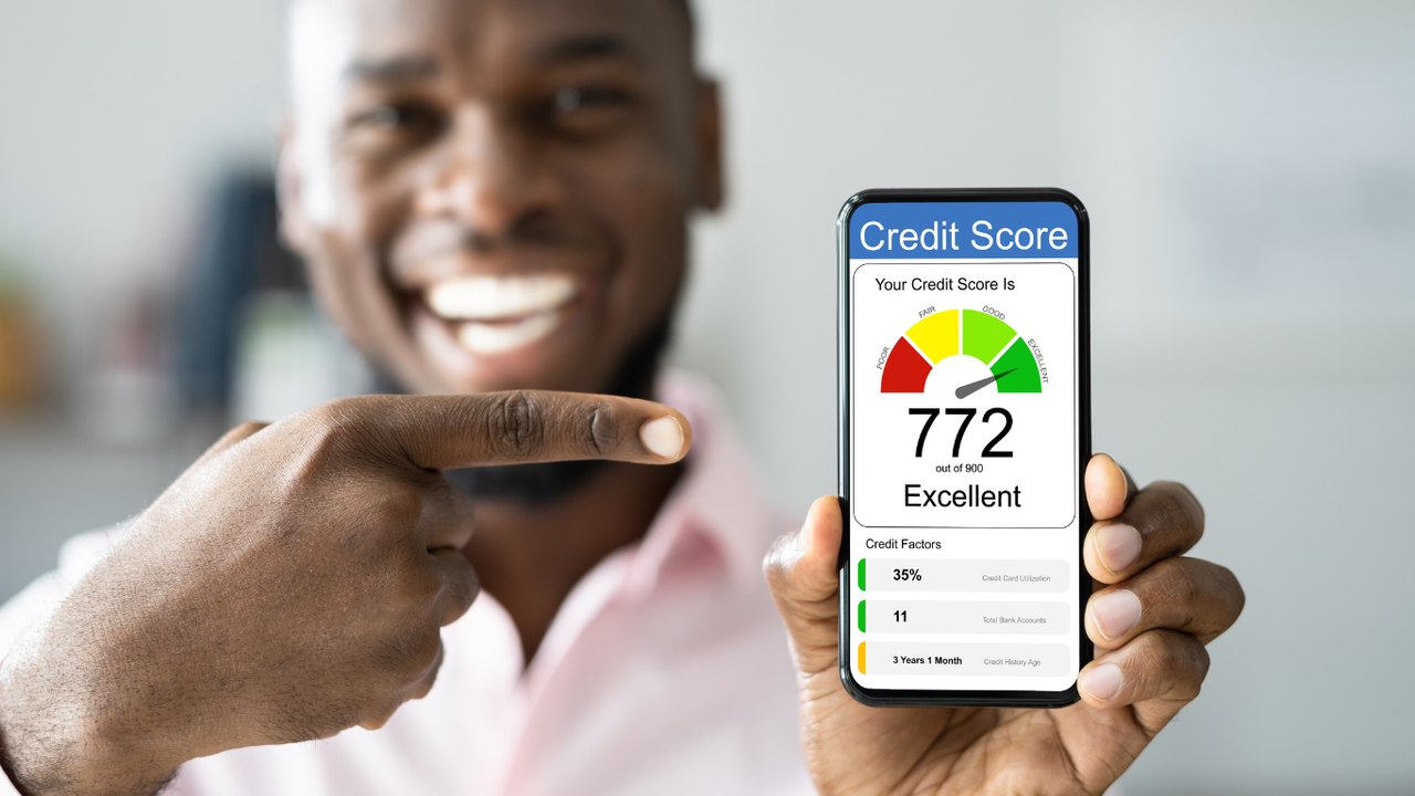 Man pointing at a phone showing an excellent credit score